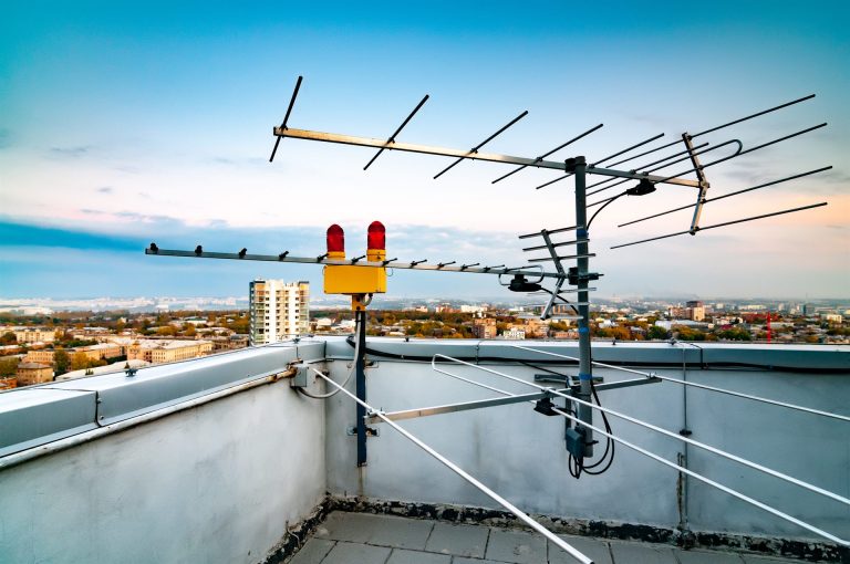 Antena de TV en el tejado de un edificio de varias plantas