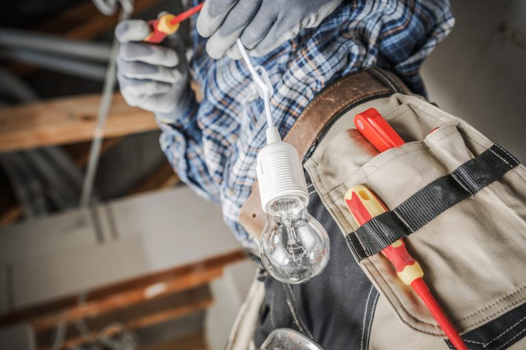 Electricista instalando un punto de luz en una vivienda